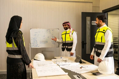 Monitoring the stages of implementing the established engineering plans, the companies specialized in construction and contracting, planning and designing architectural designs, a group of Arab Gulf Saudi engineers discuss the construction plan and accurately determine the measurements inside the company's headquarters.