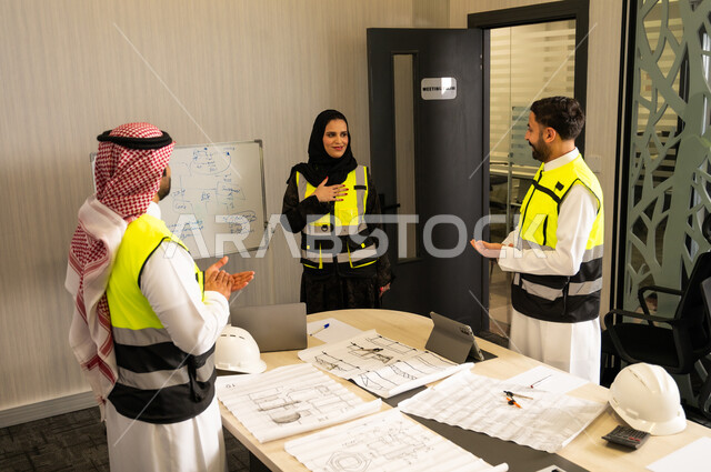 مفهوم التحفيز والدعم في بيئة العمل, إظهار التقدير أثناء عرض الأفكار, رجلان عربيان خليجيان سعوديان يرتدي الثوب التقليدي و  ستره الحماية يقومان بالتصفيق