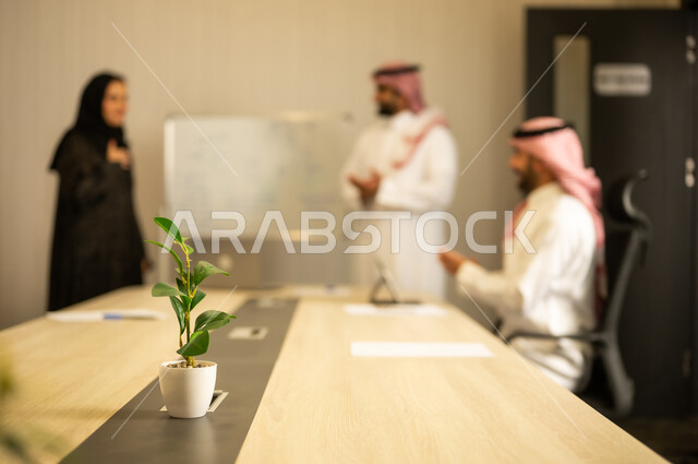 العمل الجماعي وروح الفريق، استعمال السبورة لتوضيح العمليات والاجراءات المتبعة في الشركة، ضمان فهم واضح وشامل للاعمال، ايماءات التشجيع والتصفيق، الاحترافية والتفاني في الإنجاز، رجلان عربيان خليجيان سعوديان يرتديان الزي التقليدي يقومان بالتصفيق اثناء الاجتماع
