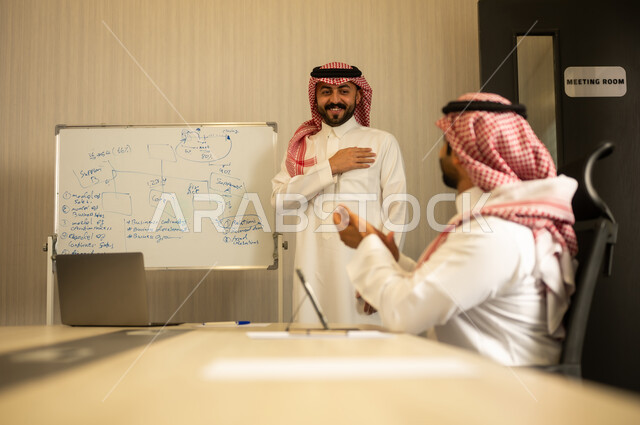 ايماءات التشجيع والتصفيق، ضمان فهم واضح وشامل للاعمال، استعمال السبورة لتوضيح العمليات والاجراءات المتبعة في الشركة، العمل الجماعي وروح الفريق، الاحترافية والتفاني في الإنجاز، رجل عربي خليجي سعودي يرتدي الثوب و الشماغ يقوم بالتصفيق