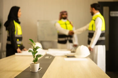 إيماءات السعادة والسرور، الشركات المختصة بورشات البناء والمقاولات، تصميم وتخطيط المخططات المعمارية، مهندسان عربيان خليجيان سعوديان يرتديان الثوب التقليدي و سترة الحماية يقومان بالمصافحة، عقد اتفاقيات عمل جديدة