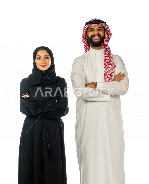 بورتريه لزوجان عربيان خليجيان سعوديان مكتفان أيديهما و يقفان معا ، ينظران إلى الكاميرا بإيماءات تدل على السعادة ، مفهوم الأسرة السعيدة ، قضاء أوقات عائلية ممتعة