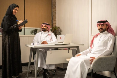 تقديم الاستشارة الطبية و الخدمة الصحية، طبيبة عربيه خليجيه سعودية محجبة تقوم بتدوين ومراجعة بيانات المريض برفقة زمليها، مفهوم الطب والرعاية الصحية