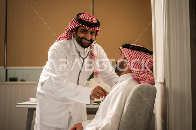 المتابعة الدورية لفحص نبضات القلب، مفهوم الطب والرعاية الصحية، قياس معدل ضربات القلب, طبيب عربي خليجي سعودي يرتدي المعطف الطبي يقوم باستخدام سماعه الفحص الطبية للمريض