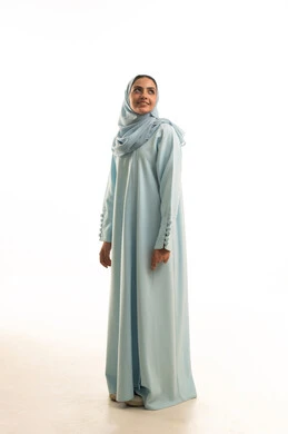 مفهوم الأنوثة والثقة بالنفس، الاهتمام بالأناقة والمظهر الخارجي، بورتريه لشابة عربية خليجية سعودية محجبة مبتسمة ترتدي العباءة تنظر الى شيء ما، ايماءات السعادة والسرور، التقاط صورة شخصية للوثائق الرسمية، الوقوف باستقامة واعتدال، الطول الكامل للجسم، خلفية بيضاء