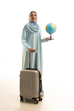 Joy for spending an enjoyable summer trip, the concept of tourism during the summer vacation, a portrait of a Saudi Arabian Gulf woman wearing an abaya and hijab standing upright, pulling a suitcase and holding a globe in her hand, gestures of happiness and joy, white background.