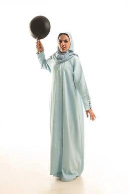 مفهوم التهديد و التحذير، بورترية لامرأة عربية خليجية سعودية محجبة ترتدي العباءة تحمل بيديها مقلاة, ايماءات الغضب والانفعال, الجسم بالطول الكامل، خلفية بيضاء