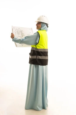 Supervision of engineering project plans, working in the field of engineering, the concept of architectural constructions, a portrait from behind of an Arab Saudi Gulf female architect wearing an abaya, a jacket, and a safety helmet holding a construction plan in her hand, a profession and job for women in the Kingdom of Saudi Arabia, white background.