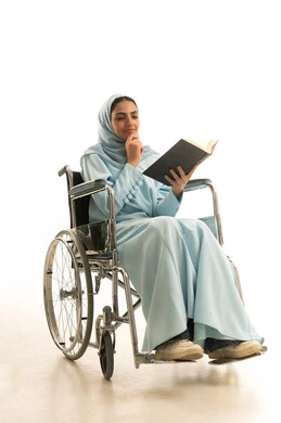 ايماءات التمعن و التركيز، تنمية المهارات الفنية والذهنية، ثقافة التعلم الذاتي، بورتريه لامراه عربية خليجية سعودية من ذوي الاحتياجات الخاصة محجبة ترتدي العباءة تجلس على كرسي متحرك تقوم بالمطالعة وقراءة الكتب المفيده، خلفية بيضاء