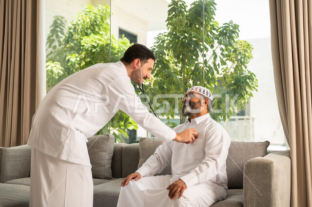متابعة الحالة القلبية من خلال فحص النبض, مفهوم الطب والرعاية الصحية, طبيب عربي خليجي سعودي يرتدي المعطف الطبي يقوم باستخدام سماعه الفحص الطبية لمريض كبير بالسن