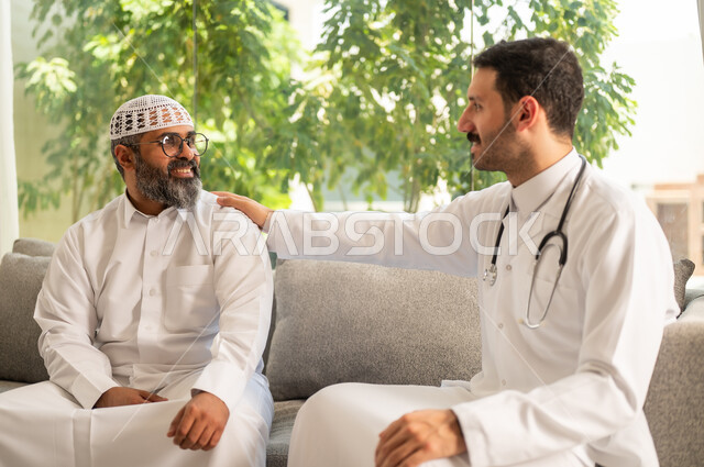 تقديم أفضل الخدمات الصحية لمرضى كبار السن في المستشفى، ممرض يرتدي اليونيفورم الخاص يقوم بطمأنة رجل عربي خليجي سعودي يرتدي الزي التقليدي ، مفهوم الطب والرعاية الصحية، تقدير الطبيب لجهوده ورعايته الطبية