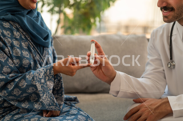 الاهتمام المستمر بالحالة الصحية لمرضى السكري, الفحوصات الطبية السريعة لمعرفة نسبة السكر في الدم، استخدام الأجهزة الالكترونية للتحاليل المنزلية، شابة سعودية مصابة بحالة مرضية مزمنة, صورة مقربة لطبيب عربي خليجي سعودي يرتدي المعطف الطبي يقوم بوخز اصبع امرأة