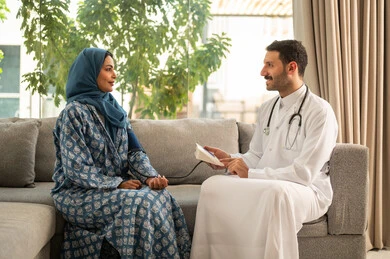 مفهوم الرعاية الصحية والاهتمام بالصحة الجسدية، استخدام الميزان الالكتروني الحديث والمتطور للفحص المنزلي السريع, طبيب عربي خليجي سعودي يرتدي المعطف الطبي يقوم بقياس ضغط الدم للمريضة في المنزل