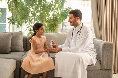 استخدام الأجهزة الالكترونية للتحاليل المنزلية، المتابعة الدورية لمرضى داء السكري، الفحوصات الطبية السريعة لمعرفة نسبة السكر في الدم، بنت سعودية مصابة بحالة مرضية مزمنة, طبيب عربي خليجي سعودي يرتدي المعطف الطبي يقوم بوخز اصبع فتاة