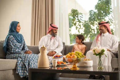 الحفاظ على صلة الرحم والترابط الأسري، مناقشات و حوارات اسرية ، فرحة وبهجة الابناء في ايام العيد السعيد, التجمعات والزيارات الاسرية في الأعياد والمناسبات الاسلامية, رجل عربي خليجي سعودي يرتدي الثوب التقليدي يجلس مع أحفاده بإيماءات الفرح والسرور