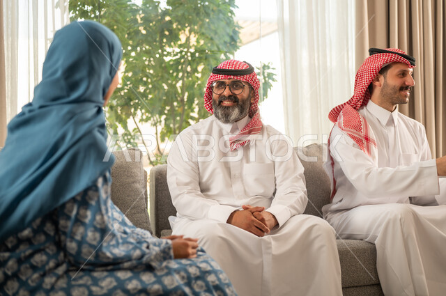 مناقشات و حوارات اسرية ، فرحة وبهجة الابناء في ايام العيد السعيد, التجمعات والزيارات الاسرية في الأعياد والمناسبات الاسلامية, رجل عربي خليجي سعودي يرتدي الثوب التقليدي يجلس مع أحفاده بإيماءات الفرح والسرور, ضيافة وحلوى العيد, حسن استقبال وإكرام الضيف، صلة الرحم والترابط الاسري