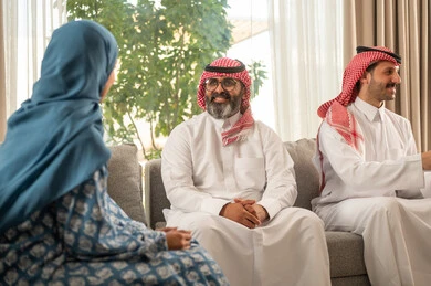 مناقشات و حوارات اسرية ، فرحة وبهجة الابناء في ايام العيد السعيد, التجمعات والزيارات الاسرية في الأعياد والمناسبات الاسلامية, رجل عربي خليجي سعودي يرتدي الثوب التقليدي يجلس مع أحفاده بإيماءات الفرح والسرور, ضيافة وحلوى العيد, حسن استقبال وإكرام الضيف، صلة الرحم والترابط الاسري