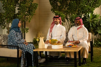 The concept of family bonding, enjoying happy family gatherings filled with love, the atmosphere of family in Saudi society during holidays and Islamic occasions, an Arab Gulf Saudi family enjoying friendly conversations.