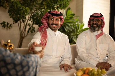 توطيد صلة الرحم وتعزيز الترابط الأسري، تقديم القهوة العربية في المناسبات الاسلامية, صورة مقربة ليد امراة عربية خليجية سعودية تقوم بتقديم فنجان القهوة, الاستمتاع بالمشروبات الساخنة, حسن الاستقبال واكرام الضيف، التجمعات والزيارات الاسرية في الأعياد والمناسبات الاسلامية