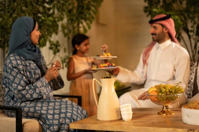 الترحيب الحسن بالضيف وإكرامه، صلة الرحم والترابط الاسري, فرحة وبهجة الابناء في ايام العيد السعيد, التجمعات والزيارات الاسرية في الأعياد والمناسبات الاسلامية, رجل عربي خليجي سعودي يرتدي الثوب التقليدي يجلس مع أحفاده بإيماءات الفرح والسرور، ضيافة وحلوى العيد