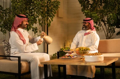 The joy and happiness of Eid among family and relatives, the hospitality and reception, the atmosphere of the Saudi family during Eid, an Arab Gulf Saudi man wearing a thobe and shemagh pouring and serving hot coffee, Eid traditions in the Saudi Gulf community, family visits and gatherings during holidays and occasions. The joy and happiness of Eid among family and relatives, the hospitality and reception, the atmosphere of the Saudi family during Eid, an Arab Gulf Saudi man wearing a thobe and shemagh pouring and serving hot coffee, Eid traditions in the Saudi Gulf community, family visits and gatherings during holidays and occasions.