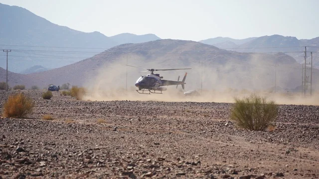 Helicopter landing on the ground, youth recreational activities, World Championship for desert rallies, Dakar Rally event in the Kingdom of Saudi Arabia, trails on the sand dunes, dune bashing on the soft sands in the desert, four-wheel drive truck.