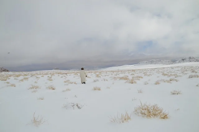 رجل يرتدي الفرو لتدفئة من الثلوج في نيوم، صورة من قمة جبل اللوز بمنطقة تبوك ، التضاريس و المناخ في السعوديه, جبال اللوز المثلجة في منطقة تبوك في المملكة العربية السعودية,  مناظر و أماكن طبيعية سياحية، المناطق الجبلية في السعودية ، وجهة العالم الجديدة في قلب نيوم