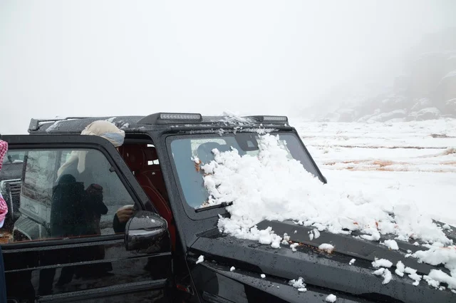 سيارة زوار لثلوج نيوم، صورة من قمة جبل اللوز بمنطقة تبوك ، التضاريس و المناخ في السعوديه, جبال اللوز المثلجة في منطقة تبوك في المملكة العربية السعودية,  مناظر و أماكن طبيعية سياحية، المناطق الجبلية في السعودية ، وجهة العالم الجديدة في قلب نيوم