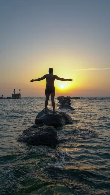 Enjoying the calm atmosphere at sunset over the Red Sea, a man in the sea, the natural environment of Jeddah's tourist corniche, recreational tourist spots in the city of Jeddah in the Kingdom of Saudi Arabia, famous tourist landmarks, Jeddah's waterfront and the tranquility of the sea.