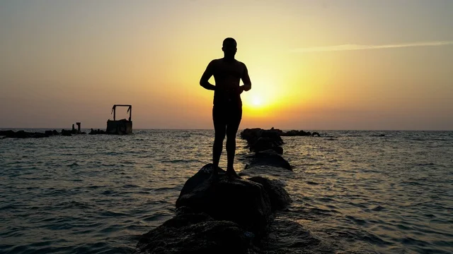 رجل في البحر، الاستمتاع بالأجواء الهادئة في وقت غروب الشمس فوق البحر الأحمر, البيئه الطبيعيه لكورنيش جده السياحي,  أماكن السياحه الترفيهيه في مدينه جده في المملكة العربيه السعوديه, معالم سياحيه مشهورة,  واجهة جدة البحرية وهدوء البحر