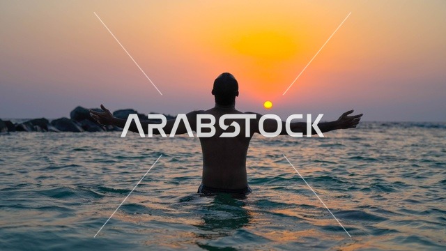 الاستمتاع بالأجواء الهادئة في وقت غروب الشمس فوق البحر الأحمر, رجل في البحر، البيئه الطبيعيه لكورنيش جده السياحي,  أماكن السياحه الترفيهيه في مدينه جده في المملكة العربيه السعوديه, معالم سياحيه مشهورة,  واجهة جدة البحرية وهدوء البحر