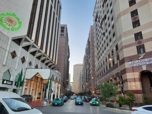 The architectural art of the buildings, towers, and hotels surrounding the Prophet's Mosque, the traffic of cars in Medina, a destination for Muslims from around the world, the view of the roads and streets during the day, famous landmarks and tourist attractions.