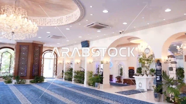 جامع عمرو بن الجموح في حي ابن خلدون (المريكبات) بمدينة الدمام، مسجد ديني اسلامي في المملكة العربية السعودية، حديقة طيور داخلية صغيرة، النجف والثريا المعلقة في السقف، النباتات الخضراء داخل المسجد، الديكور الداخلي على الطراز الاسلامي