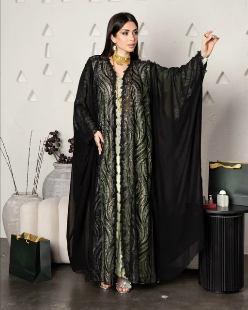 ازياء نسائية عصرية، مفهوم التجمل والاناقة والاهتمام بالمظهر الخارجي، سيدة عربية خليجية سعودية ترتددي عباءة سوداء مظرزة من الشيفون والدانتيل على الطراز العصري