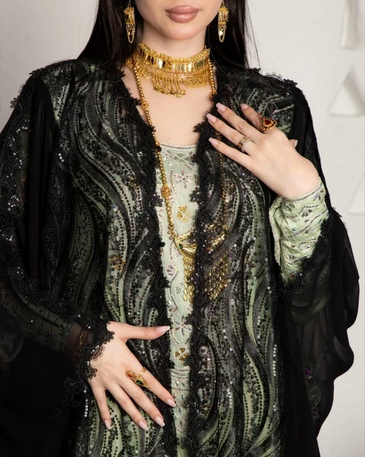 ازياء نسائية عصرية، مفهوم التجمل والاناقة والاهتمام بالمظهر الخارجي، سيدة عربية خليجية سعودية ترتددي عباءة سوداء مظرزة من الشيفون والدانتيل على الطراز العصري