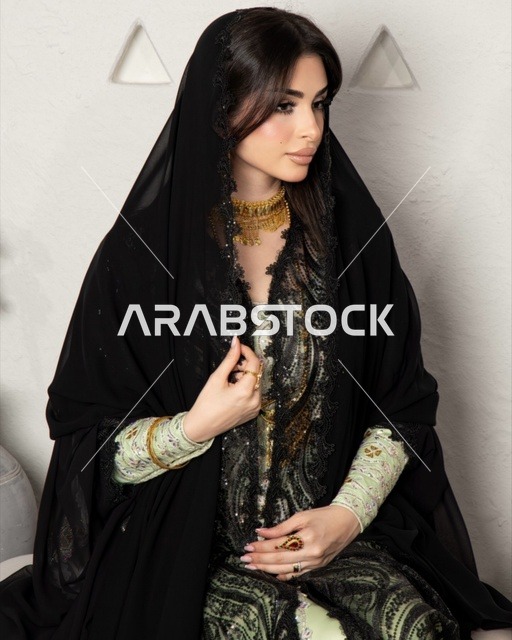 ازياء نسائية عصرية، مفهوم التجمل والاناقة والاهتمام بالمظهر الخارجي، سيدة عربية خليجية سعودية ترتددي عباءة سوداء مظرزة من الشيفون والدانتيل على الطراز العصري