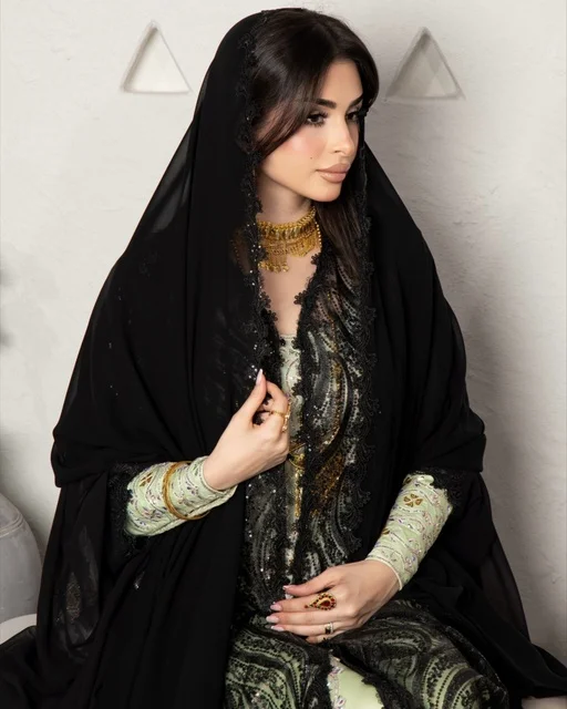 ازياء نسائية عصرية، مفهوم التجمل والاناقة والاهتمام بالمظهر الخارجي، سيدة عربية خليجية سعودية ترتددي عباءة سوداء مظرزة من الشيفون والدانتيل على الطراز العصري
