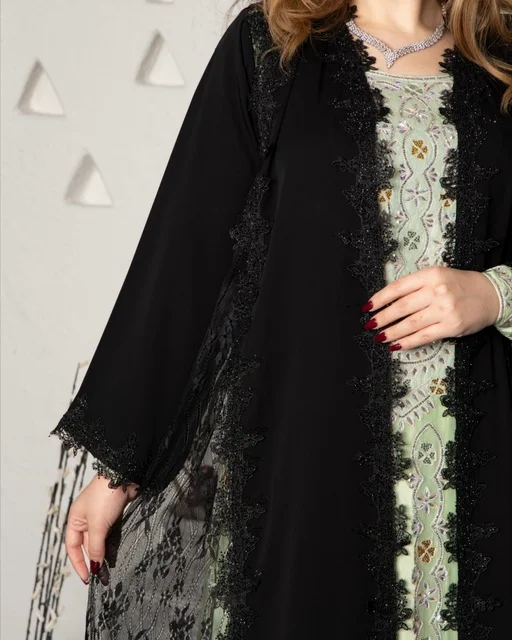 Modern women's fashion, the concept of beauty, elegance, and attention to appearance, a Gulf Arab Saudi woman wearing a black embroidered abaya made of chiffon and lace in a modern style.