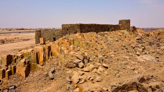 Ancient historical archaeological sites, rock formations and structures in the middle of the Saudi desert during the day, tourist attractions in the desert areas of the Kingdom, dry herbs in the desert regions.