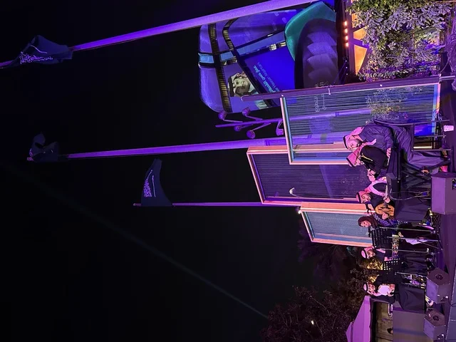 A Gulf music band at the events of the Wonders Hills Festival 2025 in the city of Jubail Industrial in the Eastern Province, operating outdoor theater platforms during nighttime events, coordinating sound and lighting equipment, theatrical performances in open spaces.