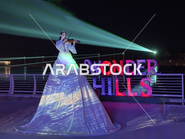 عازفة كمان بإطلالة فنية متحركة ، عروض تفاعلية ضوئية مبتكرة للعائلات والزوار، أنشطة ترفيهية وتعليمية متنوعة ، فعاليات مهرجان تلال العجائب 2025 بمدينة الجبيل الصناعية بالمنطقة الشرقية ،  وجهة سياحية للعائلات والزوار