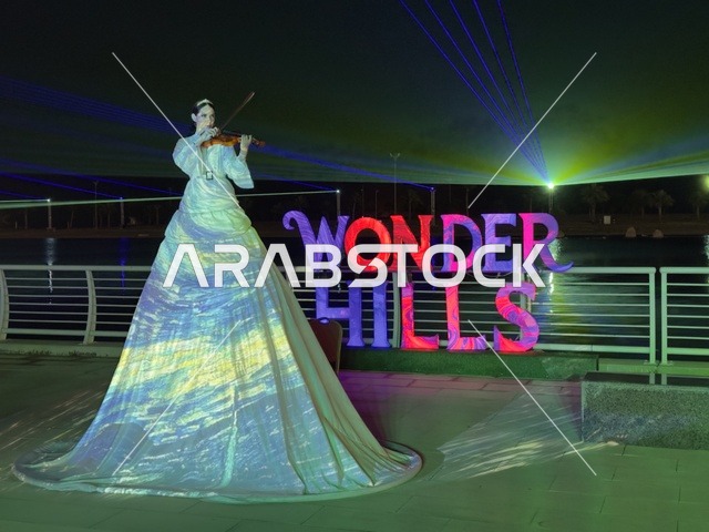 A violinist with a dynamic artistic appearance, innovative interactive light shows for families and visitors, various recreational and educational activities, events of the 2025 Wonders Hills Festival in Jubail Industrial City in the Eastern Province, a tourist destination for families and visitors.