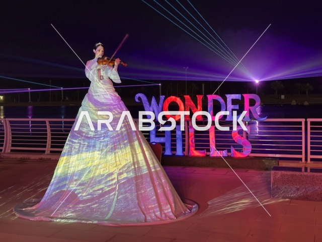 عازفة كمان بإطلالة فنية متحركة ، عروض تفاعلية ضوئية مبتكرة للعائلات والزوار، أنشطة ترفيهية وتعليمية متنوعة ، فعاليات مهرجان تلال العجائب 2025 بمدينة الجبيل الصناعية بالمنطقة الشرقية ،  وجهة سياحية للعائلات والزوار