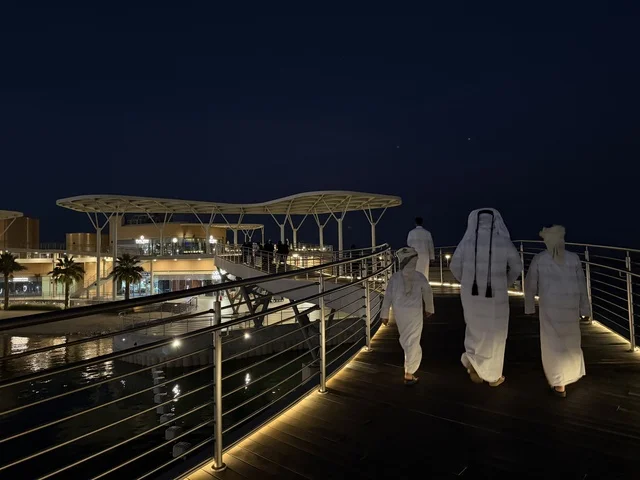 مجموعة رجال خليجية يتجولون على ممشي مجمع ذا موف بمدينة الجبيل الصناعية  في المنطقة الشرقية، ملتقى الترفيه والتسوق، كورنيش الجبيل ، معلم ترفيهي وتجاري متكامل،  أجواء نابضة بالحياة لعام ٢٠٢٥