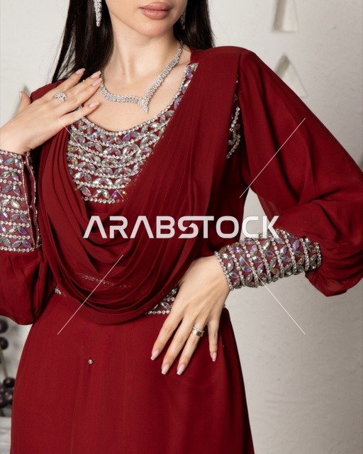 Jewelry and ornaments made of silver and diamonds, wearing a modern women's outfit, a Saudi Gulf Arab woman wearing an embroidered abaya, beauty, elegance, and attention to external appearance.