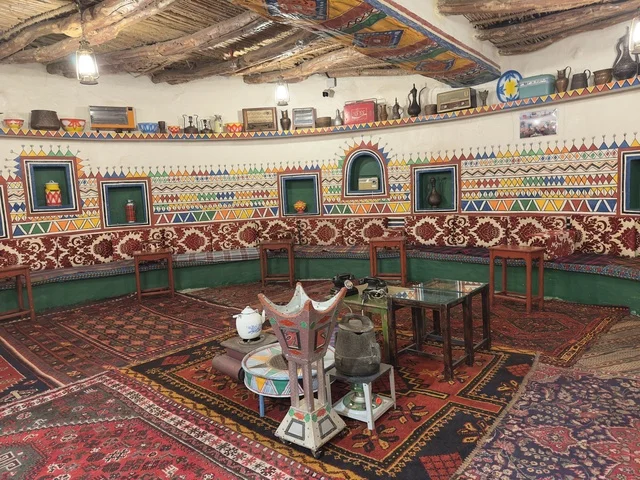 مقعد مبطن بأقمشة تراثية مخططة، الحفاظ على التراث المحلي وعرضه للزوار، القرية الشعبية التراثية متحف ومطعم بارز يقع على كورنيش الدمام في المملكة العربية السعودية،  بيئة ريفية أو تاريخية.