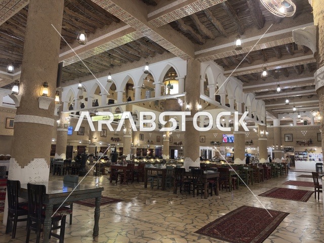 كراسي وطاولات في قاعة الطعام، الحفاظ على التراث المحلي وعرضه للزوار، القرية الشعبية التراثية متحف ومطعم بارز يقع على كورنيش الدمام في المملكة العربية السعودية،  بيئة ريفية أو تاريخية.