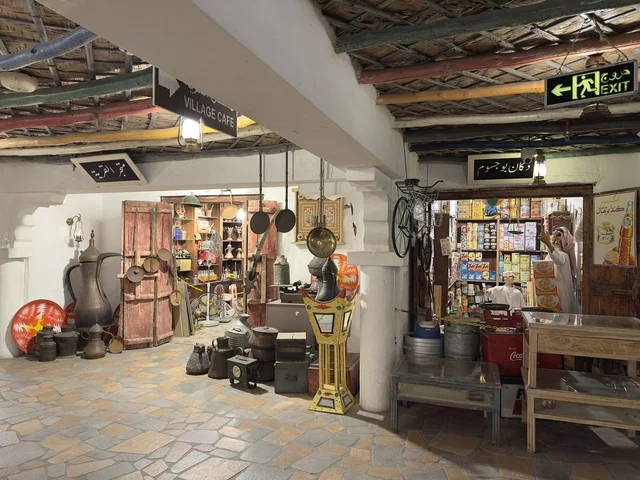 متجر القرية، يشير السهم الموجود على لافتة المخرج إلى اليسار،  بيئة ريفية أو تاريخية، الحفاظ على التراث المحلي وعرضه للزوار، القرية الشعبية التراثية متحف ومطعم بارز يقع على كورنيش الدمام في المملكة العربية السعودية