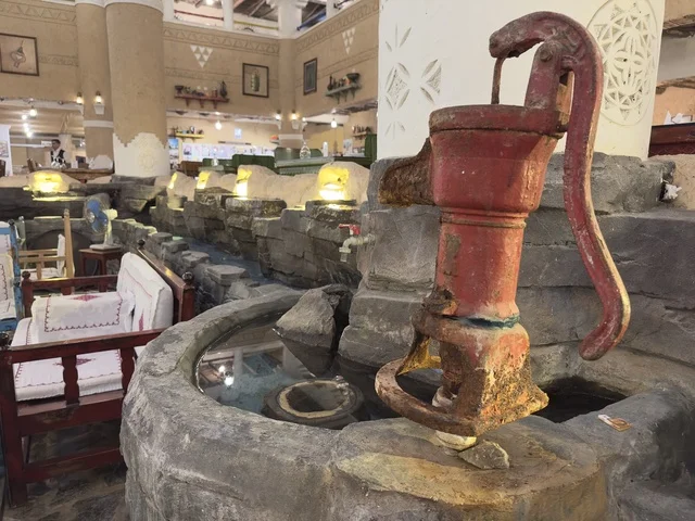 مضخة مياه يدوية من الحديد الزهر عتيقة الطراز، بيئة ريفية أو تاريخية، الحفاظ على التراث المحلي وعرضه للزوار، القرية الشعبية التراثية متحف ومطعم بارز يقع على كورنيش الدمام في المملكة العربية السعودية