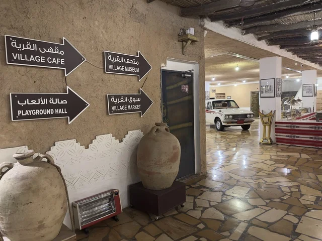 أسهم تحمل اتجاهات الاركان داخل القرية، لافته ركن الحجاز معلقة على سقف من القش والخشب، بيئة ريفية أو تاريخية، القرية الشعبية التراثية متحف ومطعم بارز يقع على كورنيش الدمام في المملكة العربية السعودية